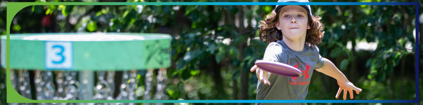 Child throwing disc towards disc golf basket 