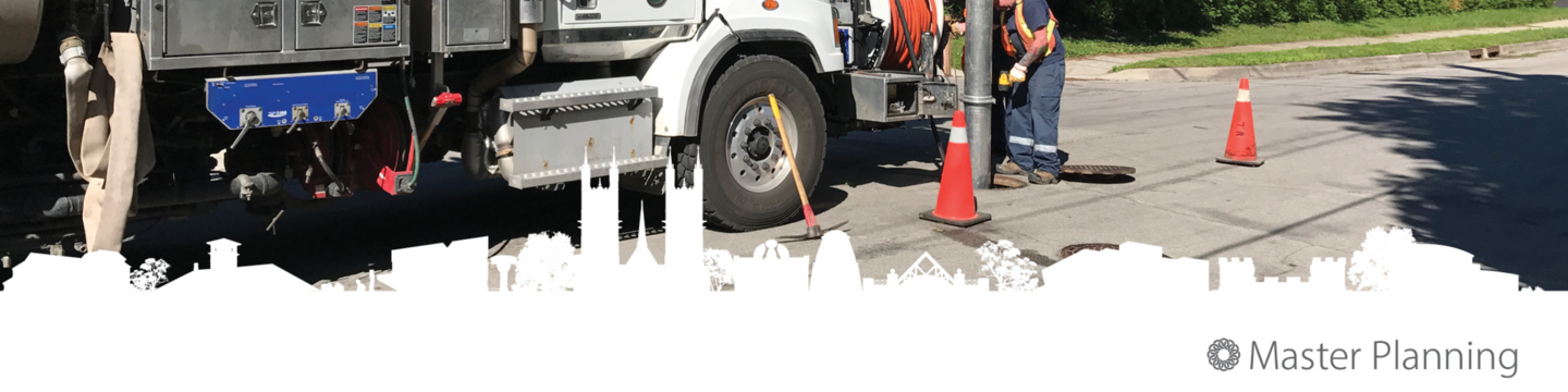 Water servicing truck working over a access point in the road