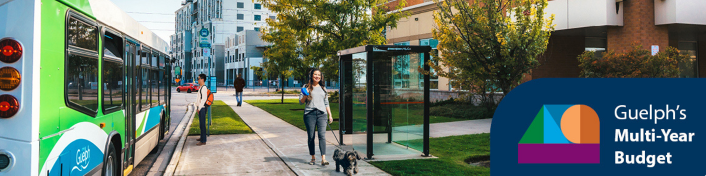 woman walking down on sidewalk as City bus drives by