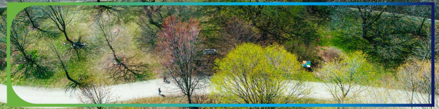 Aerial view of a park with a winding path, scattered benches, and a mix of leafy and bare trees. A few people are walking along the path. The image is framed with a gradient border transitioning from green to blue.