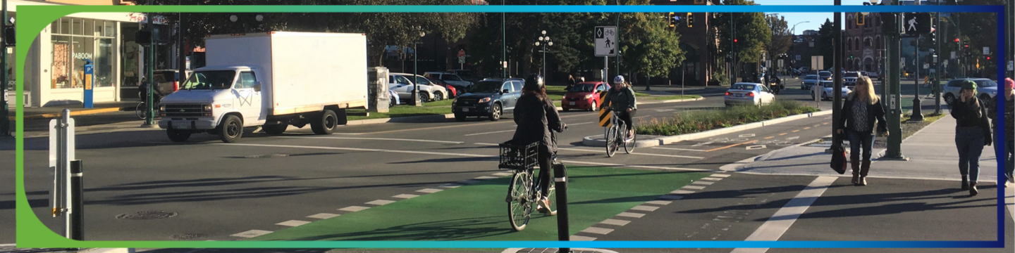 Urban intersection with cars, pedestrians, and a bike lane.