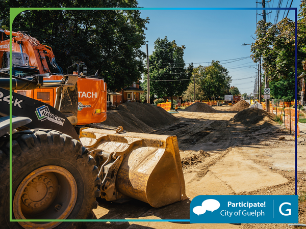 A street under construction with a backhoe in the foreground. In the bottom corner is a banner that says Participate! City of Guelph